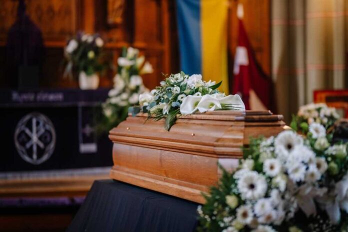 A,Coffin,Decorated,With,Many,Flowers,And,Candles,In,A