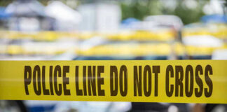 Yellow police line tape with Do Not Cross.