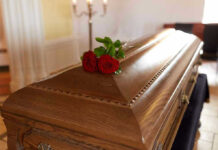 Wooden casket with red roses on top