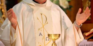 A priest performing a religious ceremony with a golden chalice