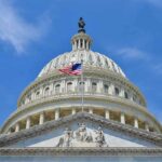 Senate Torpedoes Trump Tariffs—Nobody Predicted This The U.S. Capitol building with an American flag flying in front against a blue sky