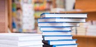 A stack of neatly arranged books on a wooden table in a bookstore