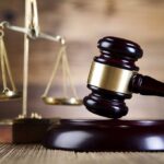 Judge’s Shocking Betrayal: Harboring Gang Ties A wooden gavel and scales of justice on a wooden surface