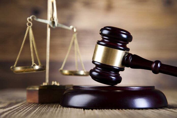 shutterstock_184689539.jpg A wooden gavel and scales of justice on a wooden surface