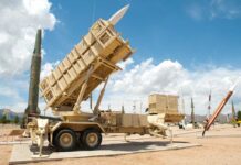 Patriot missile defense system on display outdoors with various missiles in the background