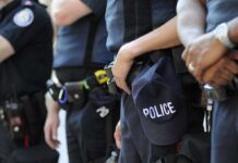 Group of police officers in uniform standing together with a police cap visible