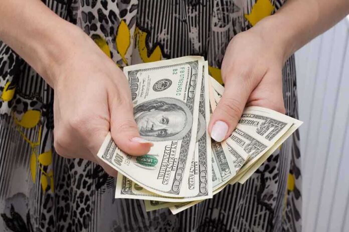 shutterstock_16350091.jpg Hands holding a fan of hundred dollar bills