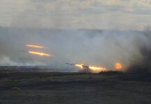 A tank firing in a smoky battlefield during a military exercise