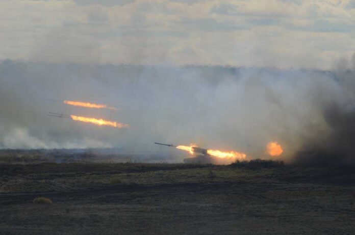A tank firing in a smoky battlefield during a military exercise