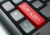 Close-up of keyboard with red SCAM ALERT key.