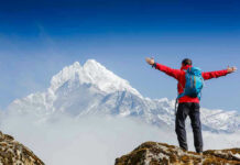 Mountaineer ABANDONS Girlfriend — MANSLAUGHTER Charges! Hiker with arms outstretched in front of snowy mountains.