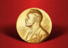 Gold Nobel Prize medal on red background.