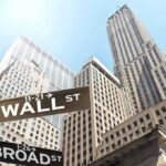 Street signs for Wall Street and Broad Street with skyscrapers in the background