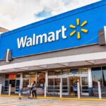 Exterior view of a Walmart store with customers entering and exiting