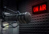 Microphone in soundproof studio with On Air sign.