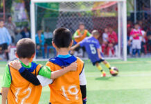 Two boys watching a soccer game together.