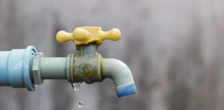 Close-up of a dripping outdoor water faucet