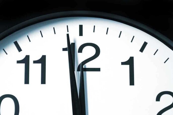 shutterstock_55812874.jpg Close-up of a clock showing the time just before noon