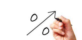 A hand drawing a percentage symbol with an upward arrow