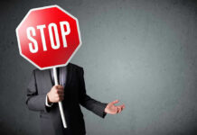 Person holding a stop sign over their face.