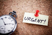 Pocket watch and urgent note pinned on corkboard