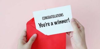 Hands holding a congratulations card and a red envelope