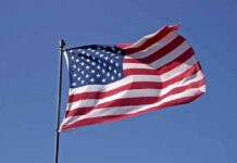 7 Years WAITING–American FLAG Flies AGAIN! Waving American flag against a clear blue sky