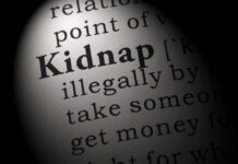 Close-up of a dictionary page showing the definition of the word 'kidnap'