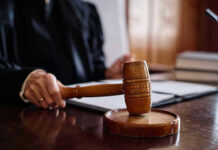Judge holding gavel in courtroom.
