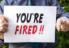 Trump’s FDA CHIEF on CHOPPING BLOCK Over Vapes Person holding YOURE FIRED sign.
