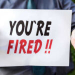 Trump’s FDA CHIEF on CHOPPING BLOCK Over Vapes Person holding YOURE FIRED sign.
