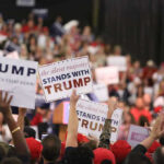 Michelle Obama’s SHOCKING Comment on Trump Voters Crowd holding signs supporting Trump at a rally.