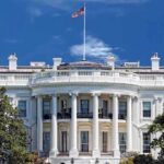 Trump–Brazil MEETING — What’s HIDDEN Behind Closed Doors? The White House with the American flag flying against a blue sky