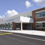 Bathroom SCANDAL Erupts: School Under Fire Modern school building with large windows and a clear sky
