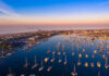 Luxury Resort Plan Triggers Protests and Corruption Probe Aerial view of marina at sunset with many boats.