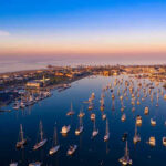 Aerial view of marina at sunset with many boats.