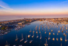 Aerial view of marina at sunset with many boats.