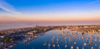Aerial view of marina at sunset with many boats.