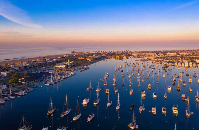 Aerial view of marina at sunset with many boats.