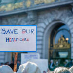 Sign reading Save Our Healthcare at protest.
