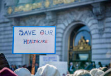 Al Gore Draws: Climate Fight to Slavery Abolition Sign reading Save Our Healthcare at protest.