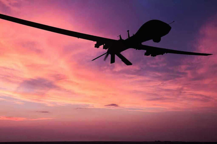 690489076-2 Silhouette of a drone against a colorful sunset.