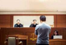 Plane Hijacker Walks Free — Judge Blamed Man stands in courtroom before judges and stenographer.