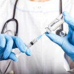 List Sparks Panic: Cancer Fears Go Viral Doctor filling syringe with vaccine from vial.