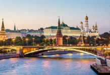 Anonymous Whale Makes Massive Bet on Putin’s Exit Illuminated bridge and Kremlin complex across river at twilight.