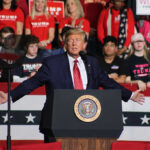 Trump’s July 4 Address Revives the Golden Age Promise Politician speaking at rally with supporters behind him.