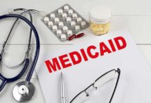 Medicaid document with stethoscope and medications on desk