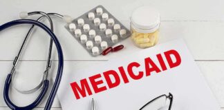 Medicaid document with stethoscope and medications on desk