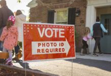 California’s Voter ID Measure Ignites New Political Battle Red voting sign with arrow near people entering a polling place