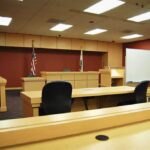 Florida’s New Death Law Tested Interior view of an empty courtroom with wooden furniture and American flags